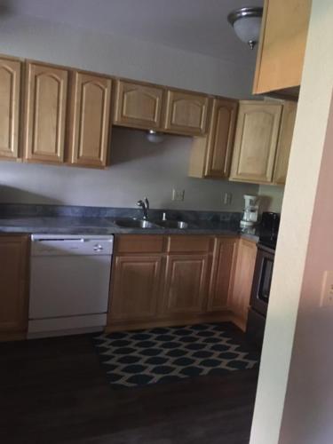 a kitchen with wooden cabinets and a sink at Dimond Jewel in Anchorage