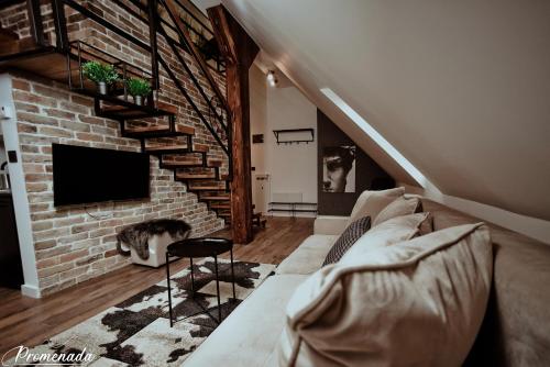 a living room with a couch and a brick wall at Promenada Apartmani Zlatibor in Zlatibor