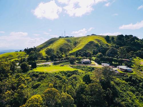 a green hill with a house on top of it at Silent Hope Cottages in Bald Knob