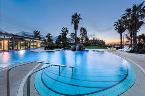 a large swimming pool with a fountain in a building at RACV Cobram Resort in Cobram