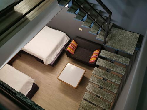 a small room with a bed and a staircase at Oasis Inn in Hengchun