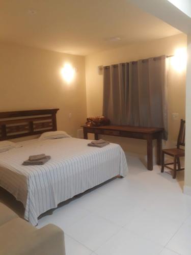 um quarto com uma cama, um banco e uma mesa em Fritz House no Rio de Janeiro