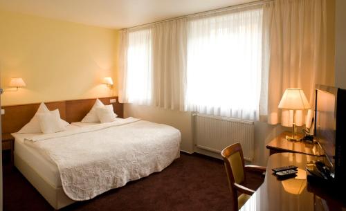 
a hotel room with two beds and a lamp at Hotel Andel in Prague

