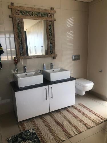 a bathroom with two sinks and a toilet at Apartment 13 Santana Pebbles, 164 South Beach Road, La Mercy in La Mercy