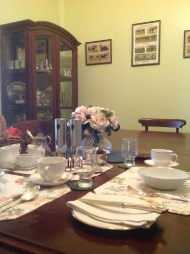 a wooden table with plates and dishes on it at Chinnock B&B in Gilgandra