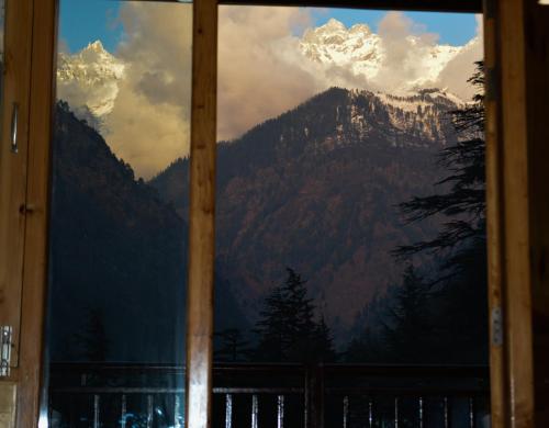 a view of a mountain through a window at The Hillside in Kasol