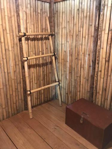 a bamboo room with a wooden ladder and a box at The Tropical Koh Mook in Koh Mook