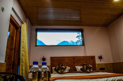 a bedroom with a bed with a television on the wall at The Hillside in Kasol