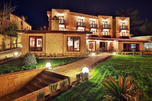 a large house with a lawn in front of it at Ida Tas Konak in Kucukkuyu