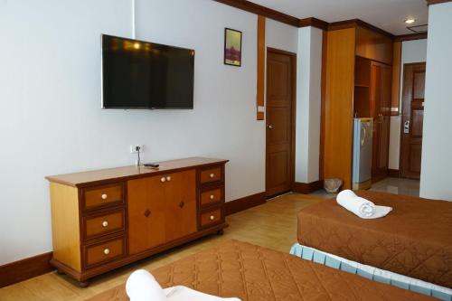 a bedroom with a dresser and a tv on the wall at อุทยานบ้านเชียงเครือ in Ban Nong Bua Sang