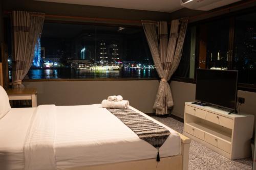 曼谷的住宿－Anandpura Riverside Hotel，一间卧室,床上有泰迪熊