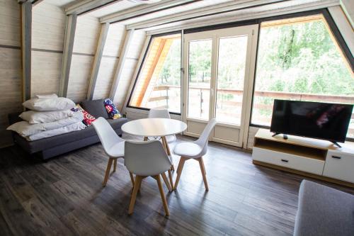 a living room with a table and chairs and a tv at Ośrodek Wypoczynkowy AKWA Marina in Nysa