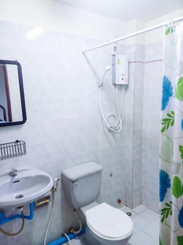 a bathroom with a shower and a toilet and a sink at FrenTé Chiang Mai in Chiang Mai