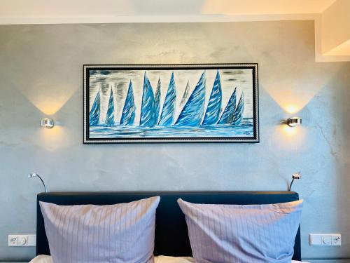 a painting of sailboats on a wall above a couch at Penthouse mit Dachterrasse PIER 5.4 in Binz