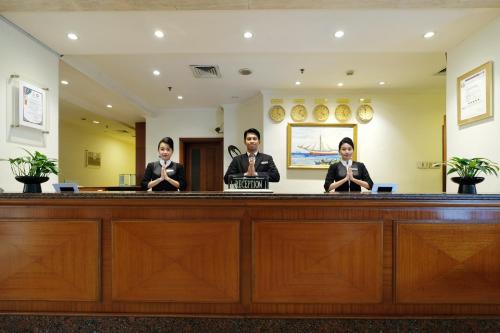 a group of people standing behind a bar at Aryaduta Makassar in Makassar