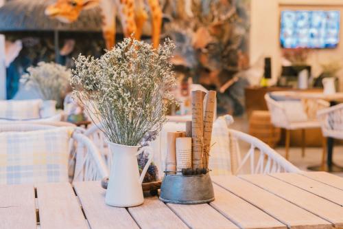 a table with a vase and flowers on it at B Innspire Hotel in Chiang Mai