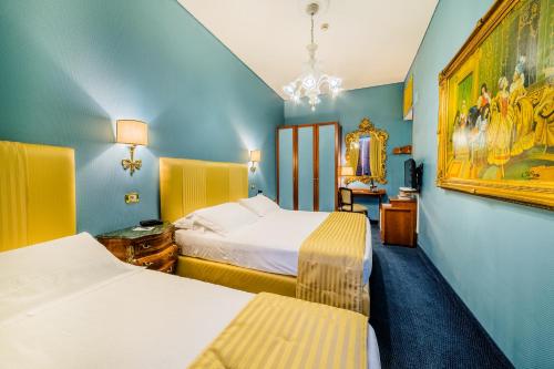 a hotel room with two beds and a mirror at Hotel Scalinata Di Spagna in Rome