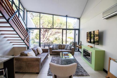a living room with a couch and a fireplace at The Glen Apartments in Cape Town