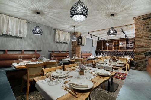 une salle à manger avec des tables, des chaises et des lumières dans l'établissement Trésor Art Boutique Hotel, à Korçë