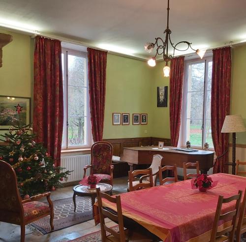 uma sala de estar com uma mesa e uma árvore de Natal em Maison d'hôtes Le Château de Puxe em Puxe