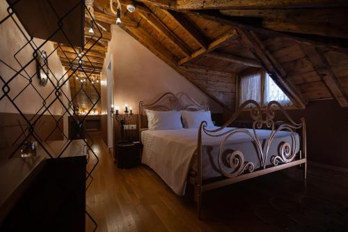 a bedroom with a bed with white sheets and a window at Trésor Art Boutique Hotel in Korçë