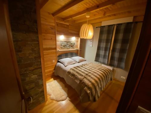 1 dormitorio con 1 cama en una habitación con una pared de piedra en Appartement rénové 4pers tout confort & garage en Cauterets