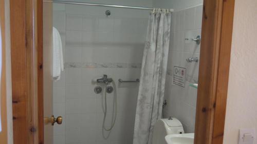 a bathroom with a shower and a toilet and a sink at Fani Hotel in Loutra Edipsou