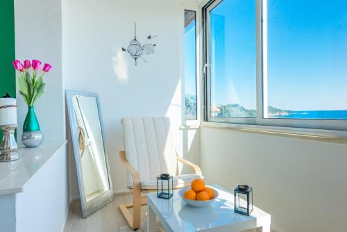 um quarto com uma cadeira e uma tigela de laranjas numa mesa em Apartment Butterfly em Dubrovnik