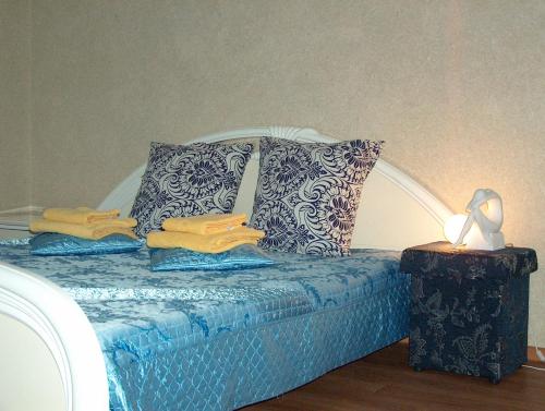 a bed with blue and white pillows and a lamp at Hotel Four Rooms on Energetikov in Tyumen