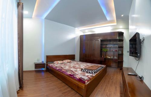 a bedroom with a bed and a tv in a room at Rosie Villa Ha Giang - Motorbikerental & Tour in Ha Giang