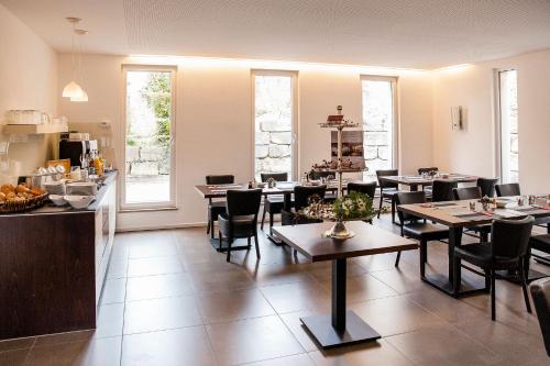 a dining room with tables and chairs and windows at Gasthof Krone in Bissingen