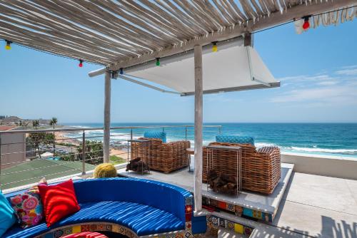 a balcony with a blue couch and a view of the ocean at The Sugar Shack in Ballito