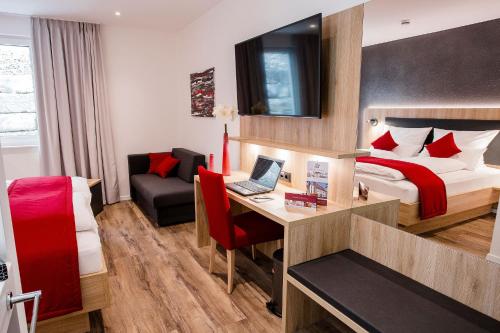 a hotel room with a bed and a desk with a laptop at Gasthof Krone in Bissingen
