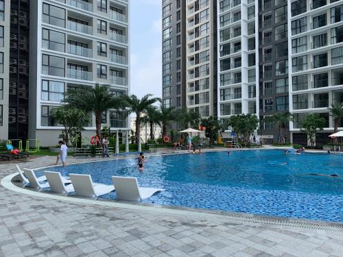 una gran piscina con sillas y edificios en Vinhomes Skylake Apartment Kangnam My Dinh, en Hanói