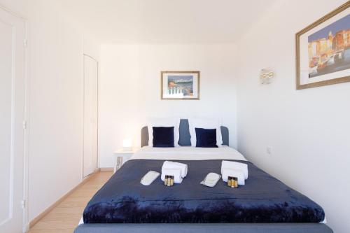 1 dormitorio blanco con 1 cama grande y 2 sillas en Alexandra YourHostHelper, en Cannes