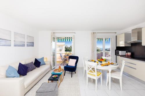 un salon avec un canapé blanc et une table dans l'établissement Alexandra YourHostHelper, à Cannes