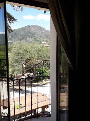 a room with a balcony with a view of a mountain at Sa Perda Arrubia in Cardedu