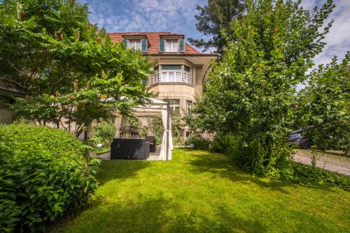 a house with a gazebo in the yard at Max Aviation Villa & Apartments in Bern
