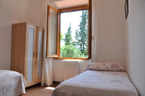 a bedroom with a bed and a window at Agriturismo Testalepre in Greve in Chianti