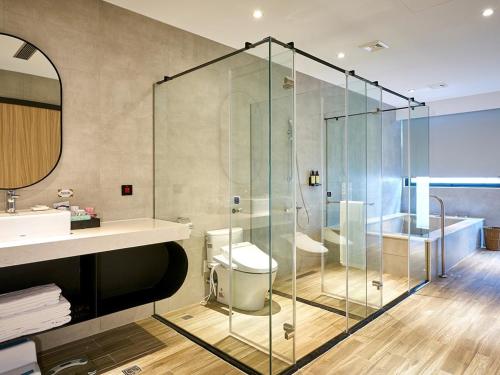 y baño con ducha, aseo y lavamanos. en The Brick Hotel en Taibao