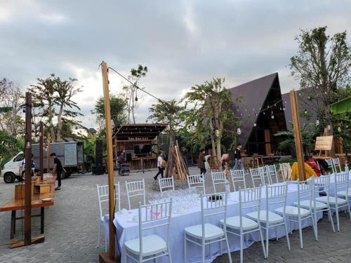 a group of white tables and chairs in front of a building at Tiên Sơn Pleiku Homestay in Pleiku