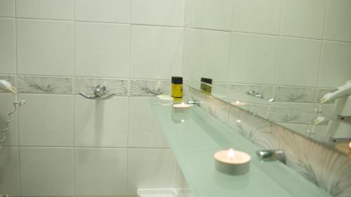 a white bathroom with candles on a counter at Fani Hotel in Loutra Edipsou