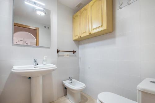 biała łazienka z umywalką i toaletą w obiekcie Apartamento en el Médano w mieście El Médano