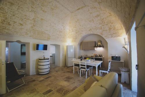 a living room and kitchen with a couch and a table at MASSERIA SCALEDDA in Manduria