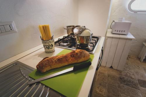 a loaf of bread on a green cutting board on a stove at MASSERIA SCALEDDA in Manduria