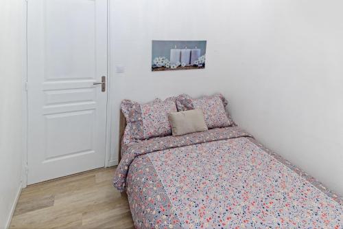 a bedroom with a bed with a floral bedspread at Le cosy fertois-self checkin-centre-ville in La Ferté-sous-Jouarre