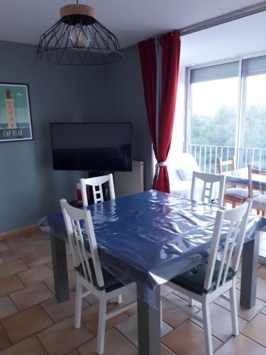 une salle à manger avec une table et des chaises bleues dans l'établissement Location Banyuls sur Mer, à Banyuls-sur-Mer