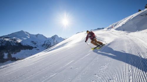 a man is skiing down a snow covered slope at Pension Alpina in Reith im Alpbachtal