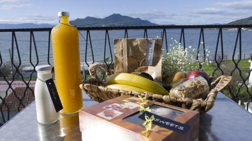 a table with a basket of fruit and a bottle of wine at Fani Hotel in Loutra Edipsou