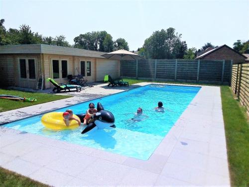 Apartment 't Maanhof في Gingelom: مجموعة من الناس يلعبون في حمام السباحة